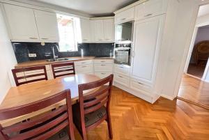 cocina con armarios blancos y mesa de madera en Cozy centrally located apartment in Reykjavik en Reikiavik