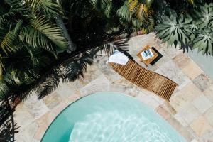 an overhead view of a swimming pool with chairs and palm trees at Cape Byron Retreat (Adults-Only) in Byron Bay