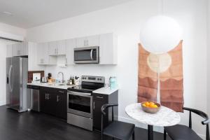 a kitchen with white cabinets and a bowl of oranges on a table at Flexhome Skywalk to Fiserv 1BR Apt U1 - READ INFO in Milwaukee