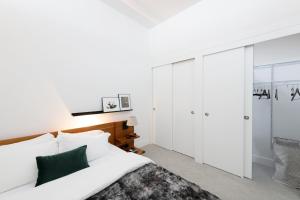 a bedroom with white walls and a bed and a closet at Flexhome Skywalk to Fiserv 1BR Apt U1 - READ INFO in Milwaukee