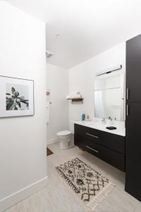 a bathroom with a sink and a mirror and a toilet at Flexhome Skywalk to Fiserv 1BR Apt U1 - READ INFO in Milwaukee