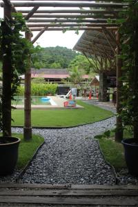 a pathway leading to a park with a pool at Bamboo Cottage Langkawi in Pantai Cenang