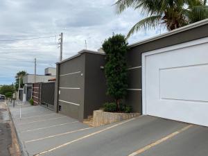 een gebouw met een witte garagedeur naast een straat bij Casa Magnífica in Olímpia