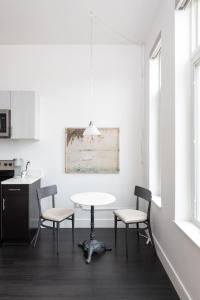 a white kitchen with a table and two chairs at Flexhome Skywalk to Fiserv 1BR Apt U3 - READ INFO in Milwaukee