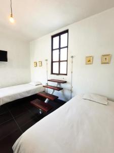 a room with two beds and a window at Casona Española in Arequipa