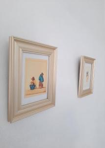 two framed pictures on a white wall at Casona Española in Arequipa