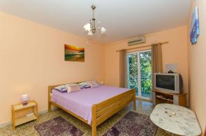 1 dormitorio con 1 cama y TV en Apartment Town View en Korčula