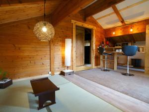 sala de estar con paredes de madera y techo en Alpages madarao, en Madarao Kogen