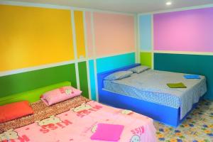 two beds in a room with colorful walls at Boon Nam Fah Resort in Chao Lao Beach