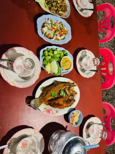 a table with plates of food and bowls of vegetables at Boon Nam Fah Resort in Chao Lao Beach