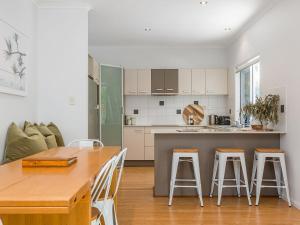 a kitchen with a table and stools in a room at Elua Beach House in Byron Bay