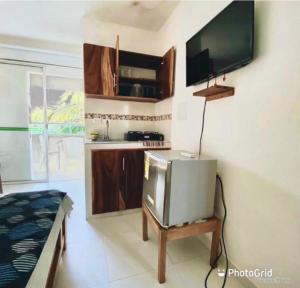 ein Wohnzimmer mit einem TV auf einem Tisch und einem TV in der Unterkunft Habitacion Coveñitas 201 in Coveñas