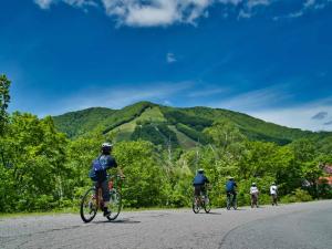 Un grupo de personas que van en bicicleta por una calle en Madarao Vacances Village, en Iiyama 78 fotos más
