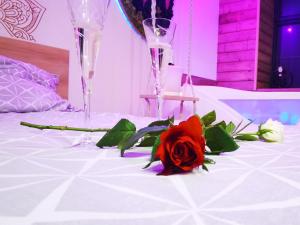 uma rosa vermelha numa mesa com duas taças de champanhe em ÉDEN em Brie-Comte-Robert
