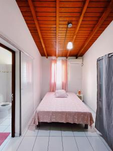 薩萊比梅的住宿－La Villa Ixora, magnifique Villa avec Piscine，一间卧室设有一张木天花板床。