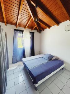 una camera con letto e soffitto in legno di La Villa Ixora, magnifique Villa avec Piscine a Les Abymes