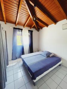 a bedroom with a bed and a wooden ceiling at La Villa Ixora, magnifique Villa avec Piscine in Les Abymes +8 photos