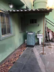La salle de bains est pourvue de toilettes et d'un mur vert. dans l'établissement !!Casa na Penha toda Mobiliada em rua Tranquila!, à Rio de Janeiro