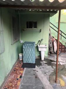 Cette chambre verte comprend un lavabo et des toilettes. dans l'établissement !!Casa na Penha toda Mobiliada em rua Tranquila!, à Rio de Janeiro