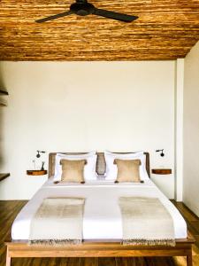 a bedroom with a white bed with a wooden ceiling at Mayara pool villas in Haad Yao