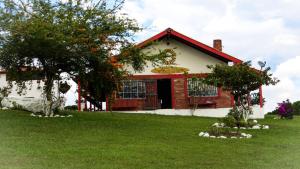 una casa roja y blanca con un árbol en el patio en Hospedaje Casona Villa Alicia, en Los Santos