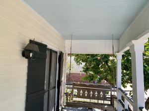una casa con una puerta verde y un porche en The Cottages at Capitol Park, en Baton Rouge