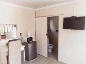 a small bathroom with a toilet and a microwave at Gabade Guest House in KwaDukuza