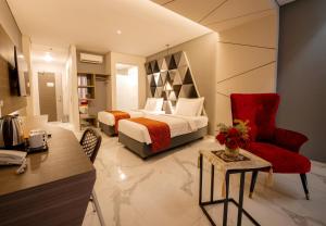 a bedroom with a bed and a desk and a chair at Swiss-Belcourt Kupang in Oesapa-besar