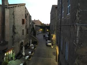 維泰博的住宿－l'eco dei Papi，一条小巷,在街道上停有汽车,街道上建有建筑