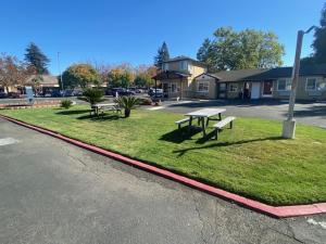 two picnic tables on the grass near a street at North Bay Inn Santa Rosa in Santa Rosa