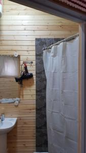 a bathroom with a sink and a white shower curtain at Boutigue Hotel Nebesa in Chimgan