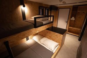 two bunk beds in a room with a hallway at Bear Grylls Explorers Camp in Ras al Khaimah