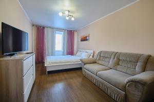 a living room with a couch and a flat screen tv at Apart Petrovskie on Sovetskaya 69 in Tomsk