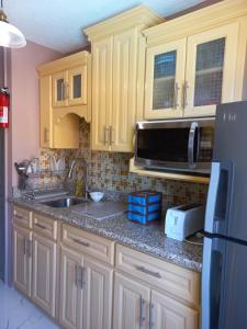 a kitchen with a sink and a microwave at Towers by the Beach in Ocho Rios