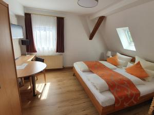 1 dormitorio con cama, escritorio y mesa en Eichamt, en Sigmaringen