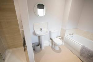 a bathroom with a sink and a toilet and a mirror at Entire Duplex apartment for up to 6 guests, free wifi in Darlington