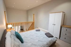 a bedroom with a large bed and a staircase at Entire Duplex apartment for up to 6 guests, free wifi in Darlington