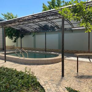 a swimming pool under a metal canopy in a courtyard at Premium hostel in Tashkent