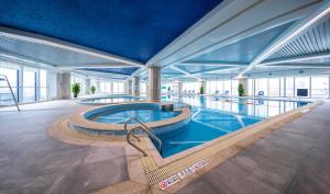 a large building with a swimming pool in a building at Tonino Lamborghini Hotel Kunshan City Center in Kunshan