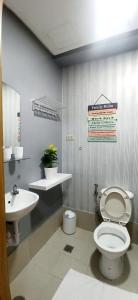 La salle de bains est pourvue de toilettes et d'un lavabo. dans l'établissement 2-Bedroom CK's Corner Staycation Trees Residences, à Manille