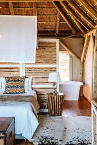 1 dormitorio con 2 camas y bañera en Jbay Zebra Lodge, en Longmore