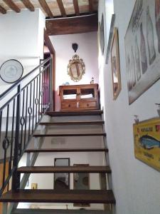 kręte schody w domu z zegarem na ścianie w obiekcie B&B IL Giardino del Borgo w mieście Veiano