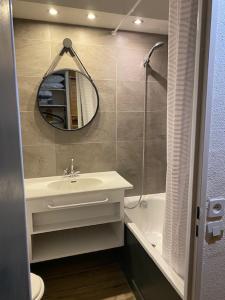 un bagno con un lavandino, uno specchio e una vasca di Studio au pied des pistes et funiculaire a Tignes Altre 6 foto