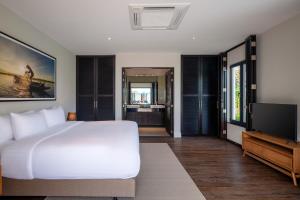 - une chambre avec un lit blanc et une télévision à écran plat dans l'établissement Ultimate Luxury Bali Style Villa with 5 Bedrooms! B11, à Hua Hin