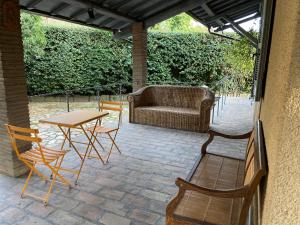 a patio with a table and chairs and a couch at Villa Adriana Tuscia Country Retreat in Vetralla