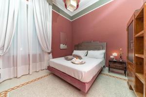 a bedroom with a large bed with pink walls at IL FIORE D'ORO LUXURY in Naples