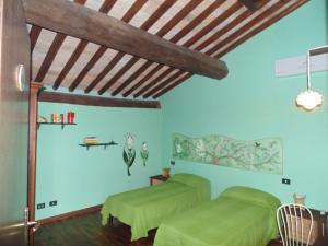 a bedroom with two green beds and a wooden ceiling at B&B IL Giardino del Borgo in Veiano