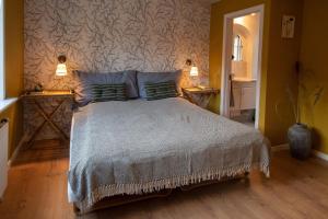 a bedroom with a bed with two lamps on two tables at Kroghuset - Det Lille Hotel in Tarm