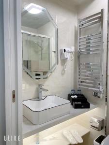La salle de bains blanche est pourvue d'un lavabo et d'un miroir. dans l'établissement KYRIAD ROUEN SUD - Sotteville les Rouen, à Rouen