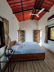 1 dormitorio con 1 cama grande y mesa de cristal en Roy's Nature Nest - Farm Stay near Malshej Ghats, en Ghātghar